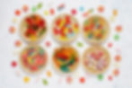 Alt text: Six bowls of different candies with some scattered on the table.